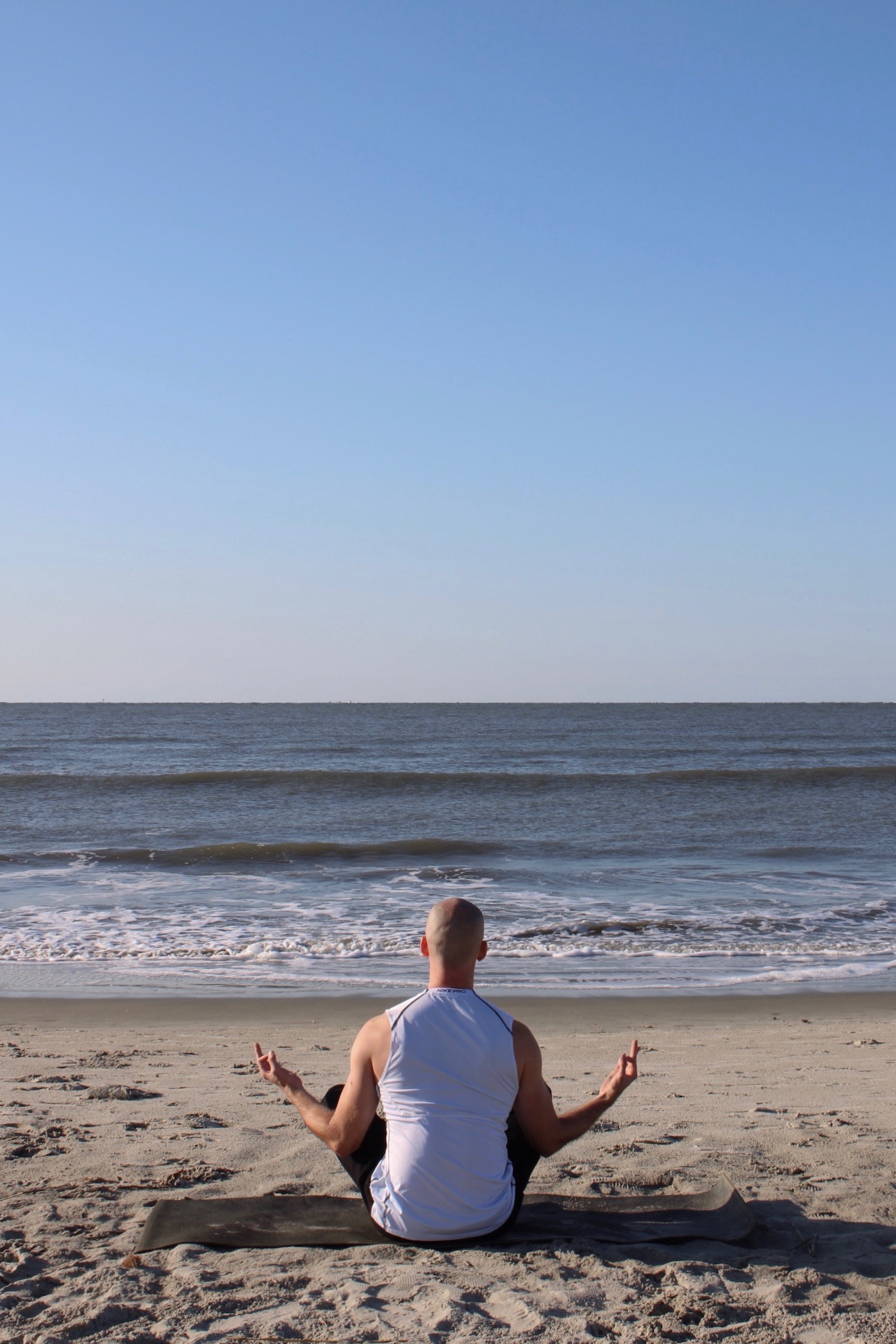 Man standing with arms open in front of a mountain, symbolizing strength, confidence, and personal growth.