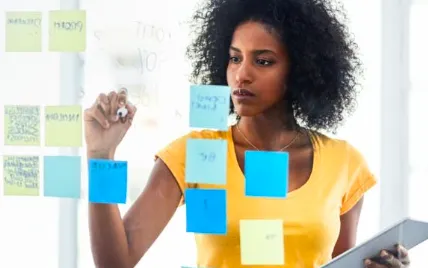 woman writing on sticky notes