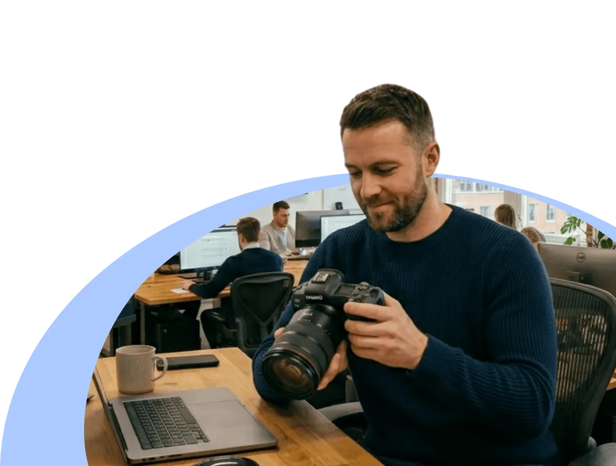 a man holding a high performance camera in the office