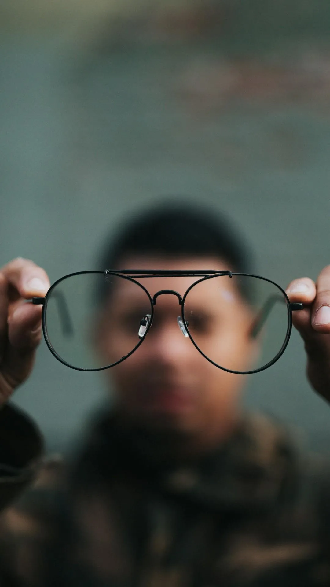 a man holding glasses up showing the camera