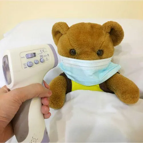 teddy bear with a thermometer to its head