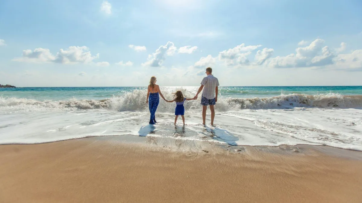 family holding hands at the beach