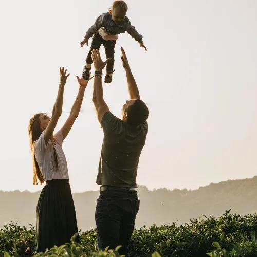 family throwing a kid in the air showing love