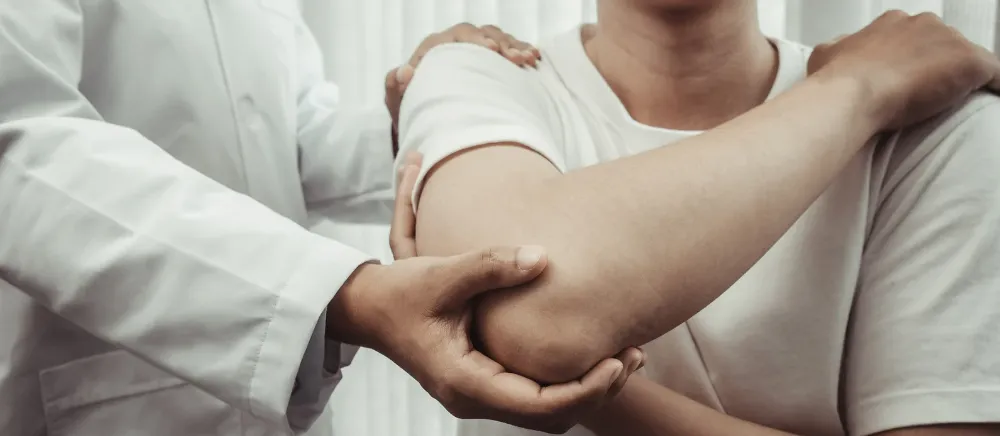 octor performing elbow examination on a patient experiencing pain
