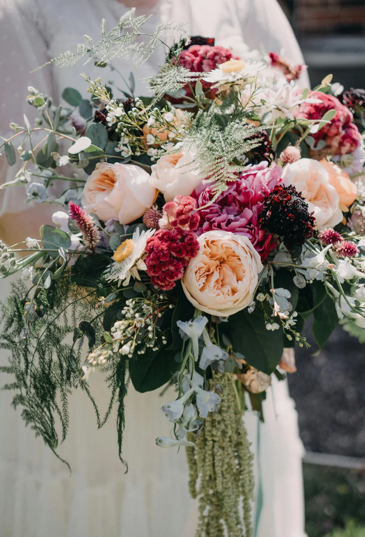 Bouquet de mariée champêtre de roses pêche, célosies et amarante retombante