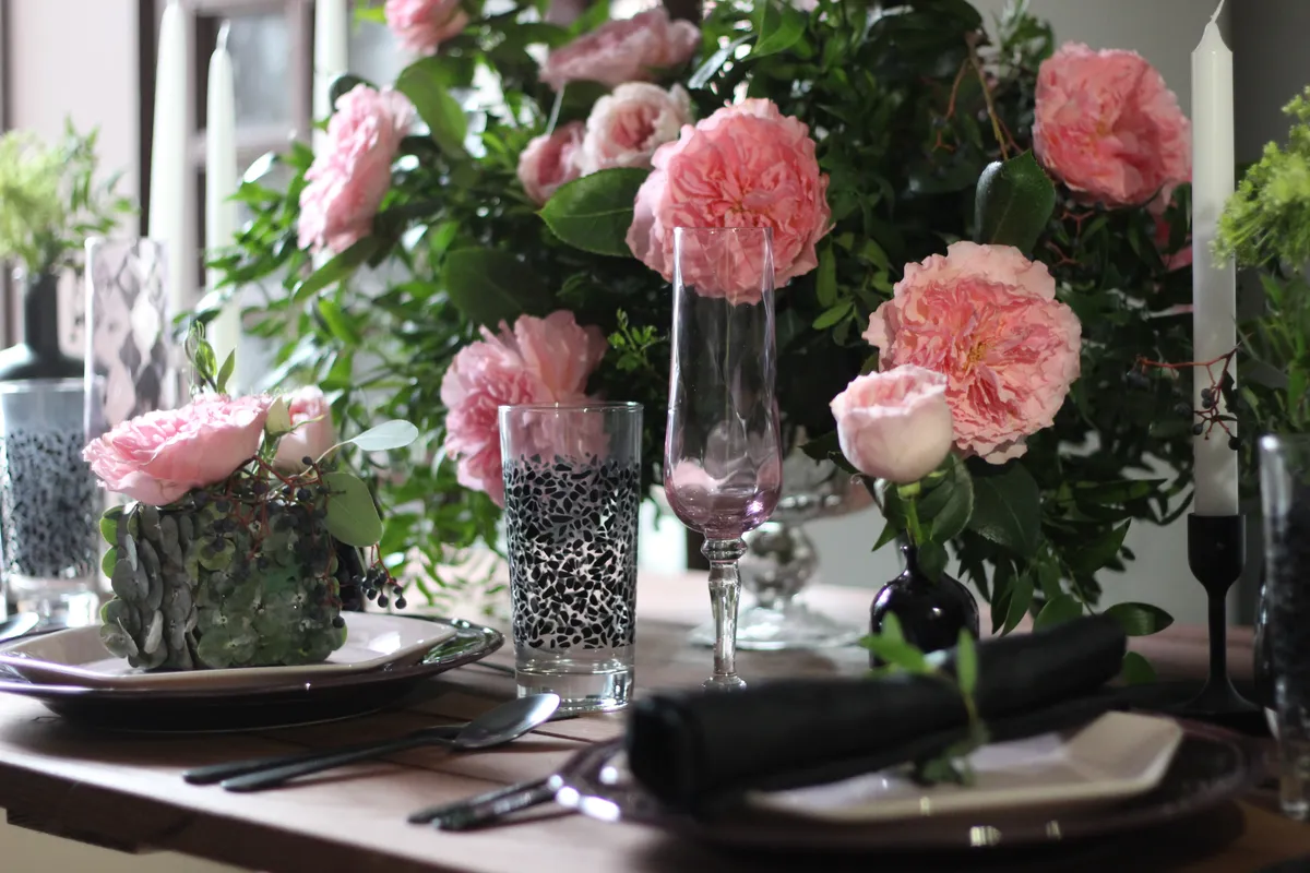 Roses de jardin roses sur une table de souper