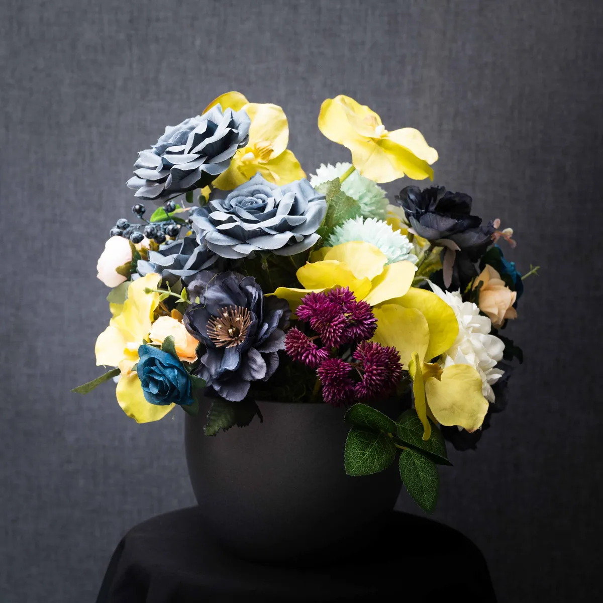 Arrangement de fleurs artificielles dans un vase noir