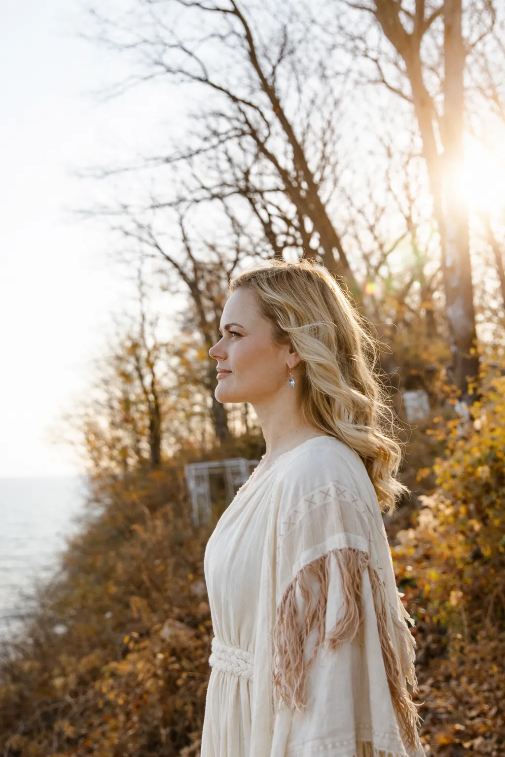 Portrait of a confident workshop leader, mid-30s, warm studio lighting, soft neutral wardrobe, standing three-quarter, photorealistic editorial, conveys calm authority and approachability for NovaNest cohort audience.