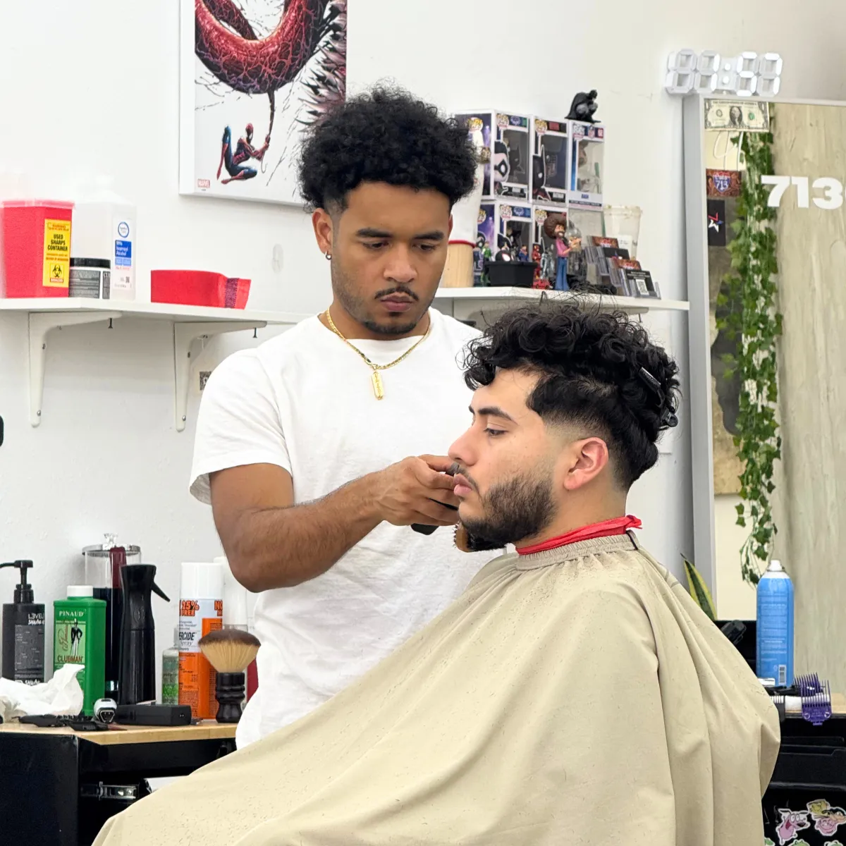Barber giving a low fade on curly hair with a beard