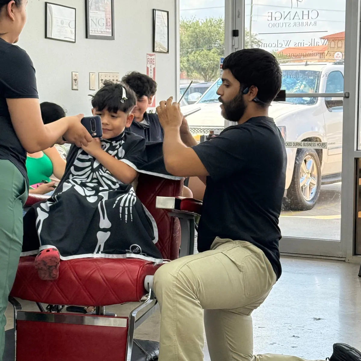 Barber giving a kids fade haircut on straight hair.