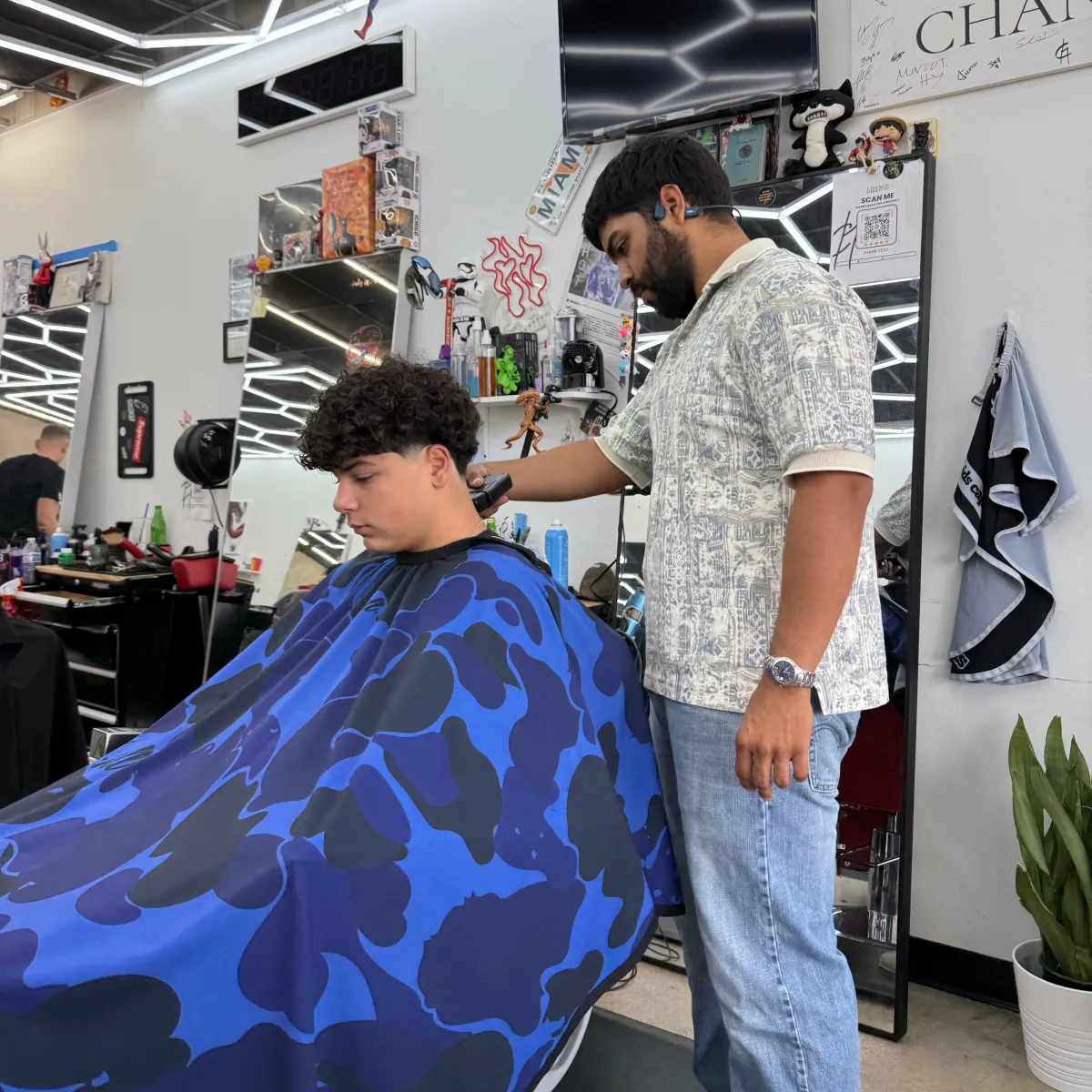 Barber giving a taper fade on curly hair