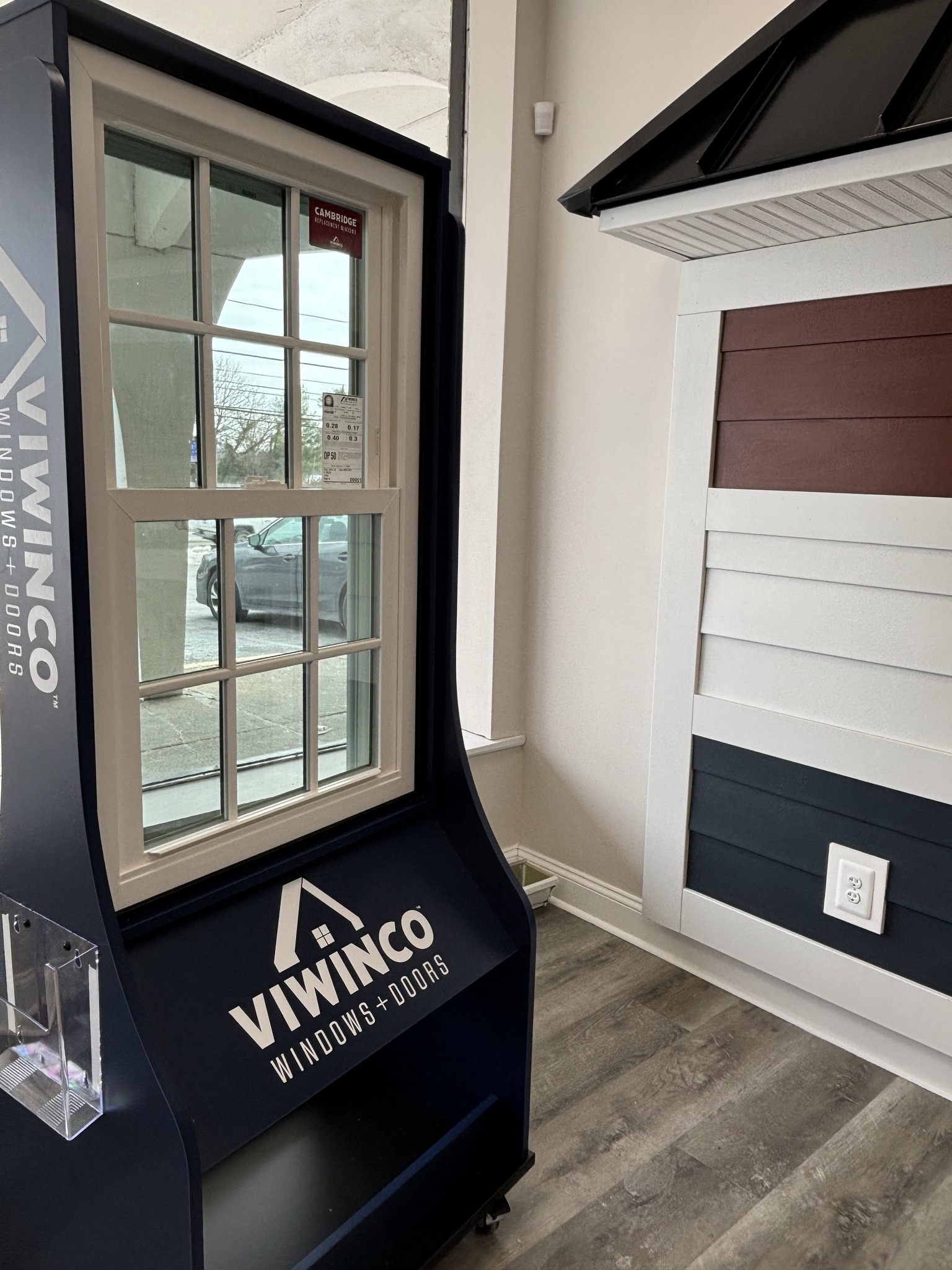 A bird sitting on top of a roof next to a building