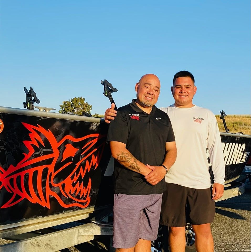 Father and son fishing captains holding a large catch