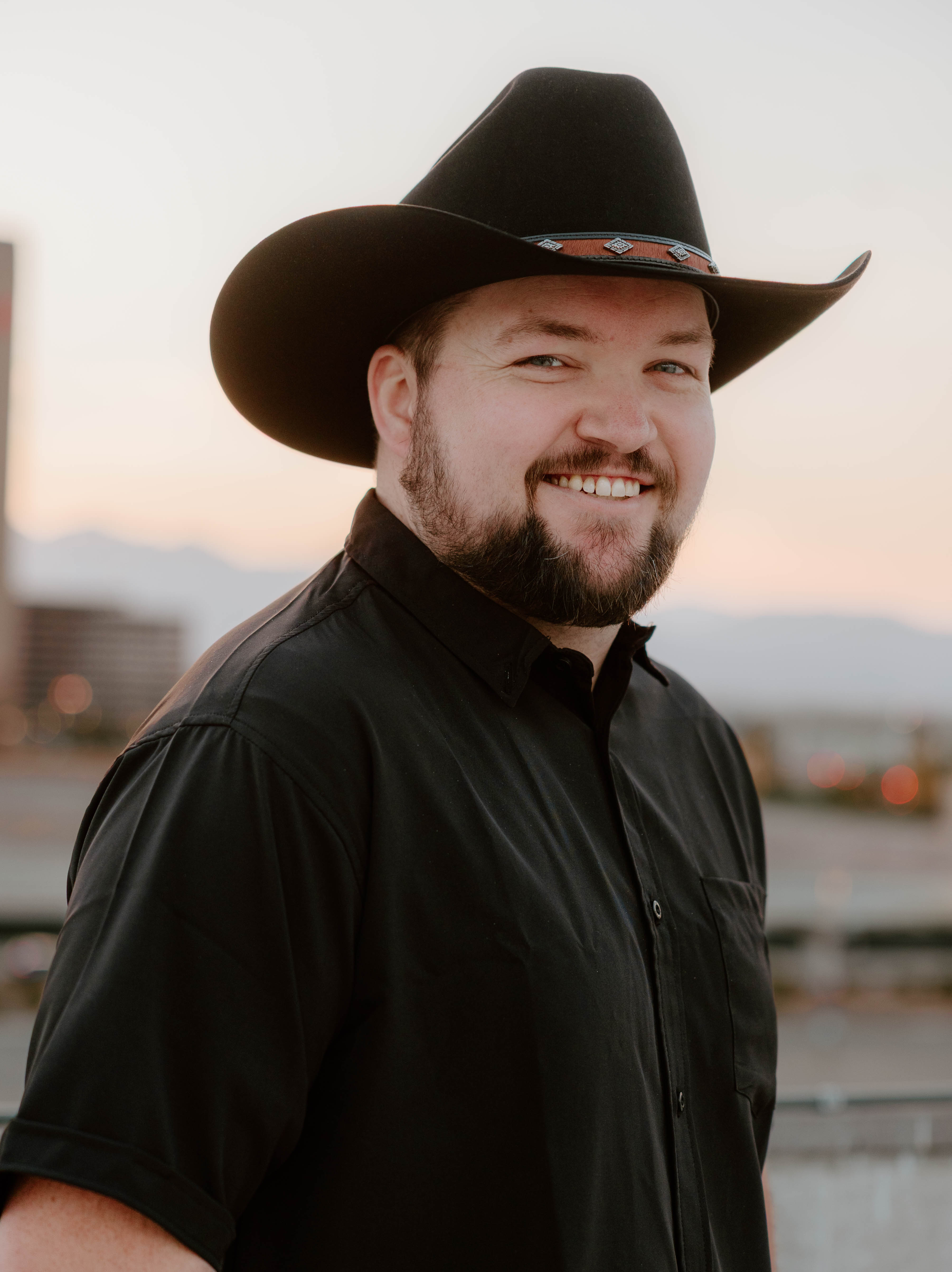 Portrait of a mid-30s male founder, gentle smile, navy-blue background, blazer, photorealistic editorial style