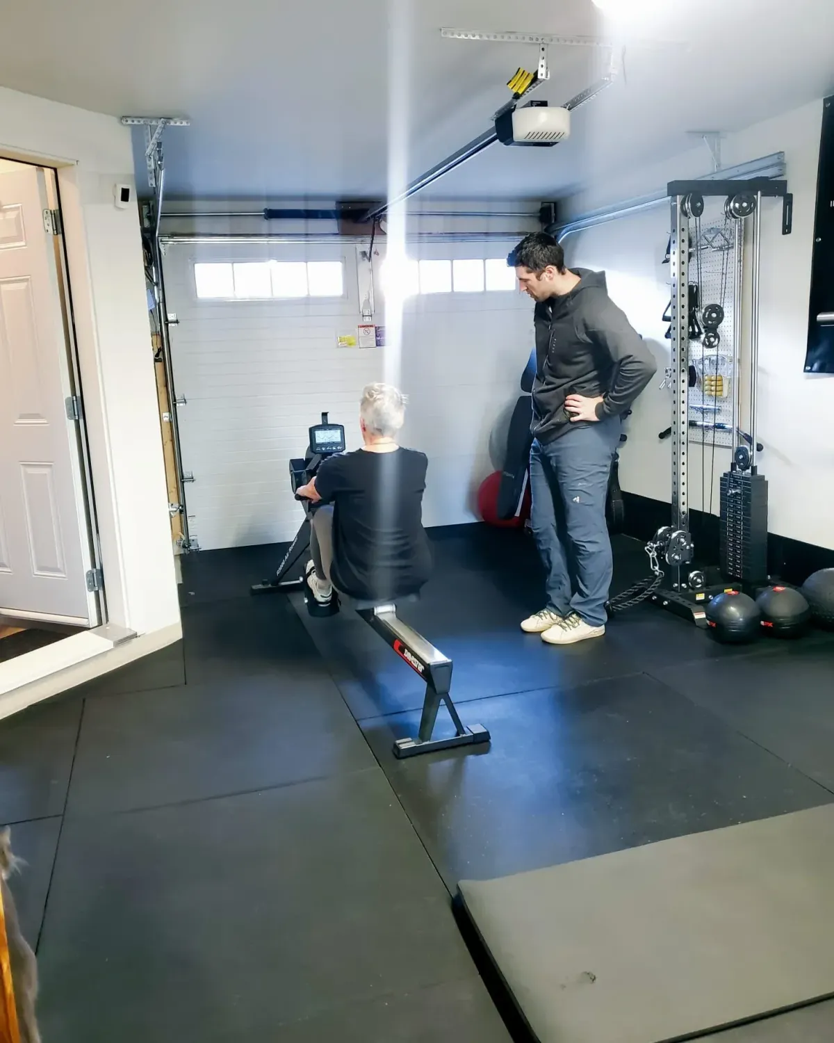 This is an image of our head coach Ethan Tripp training a client using a rowing machine