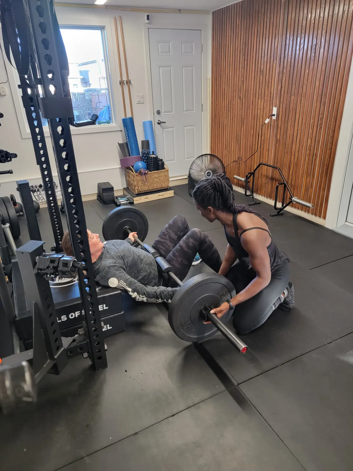 Coach Ice teaches a woman the hip thrust technique, perfect for strengthening the lower body. 