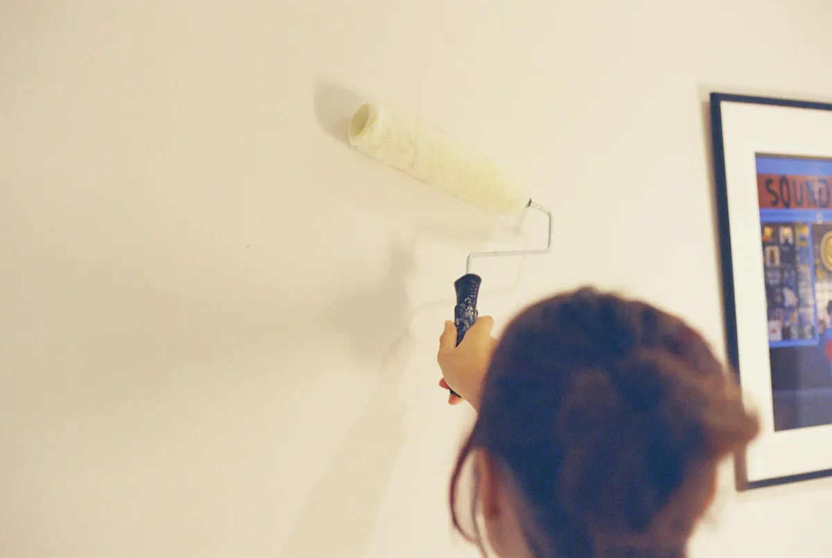 Painter rolling a fresh coat of paint onto an interior wall