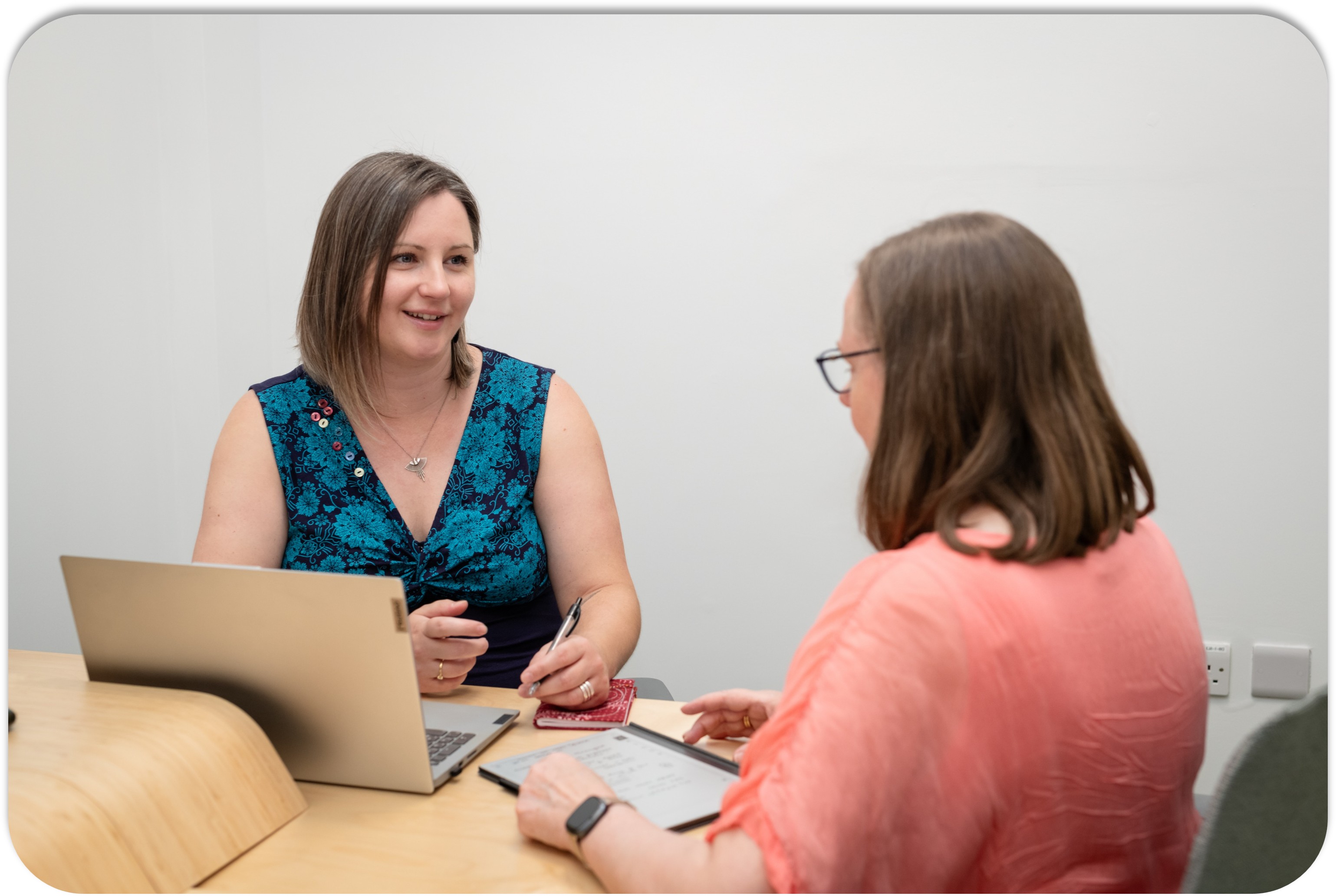 Georgie and Karen in discussion at their desk