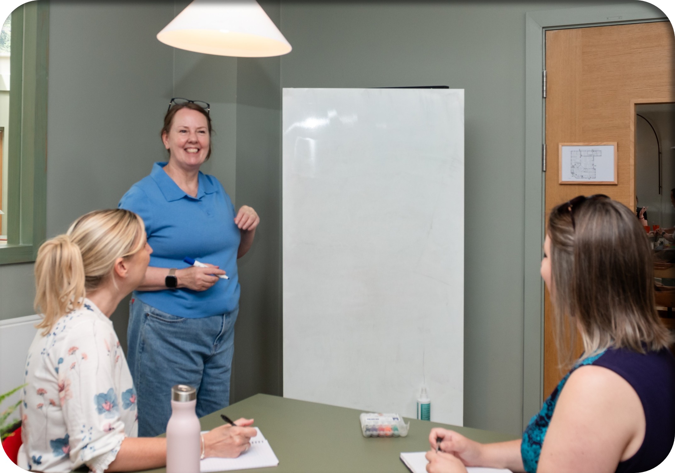 Team discussing ideas by whiteboard