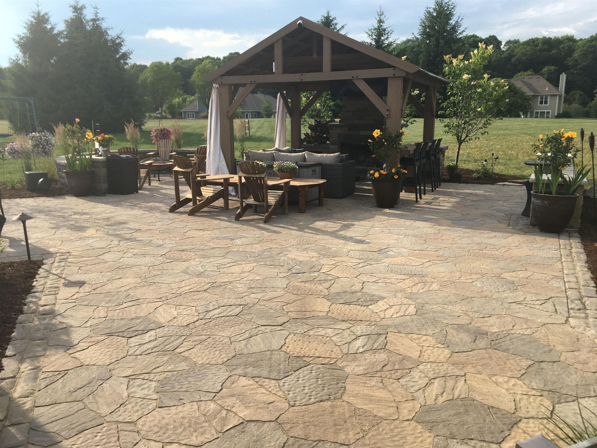 a paver patio and pergola with seating