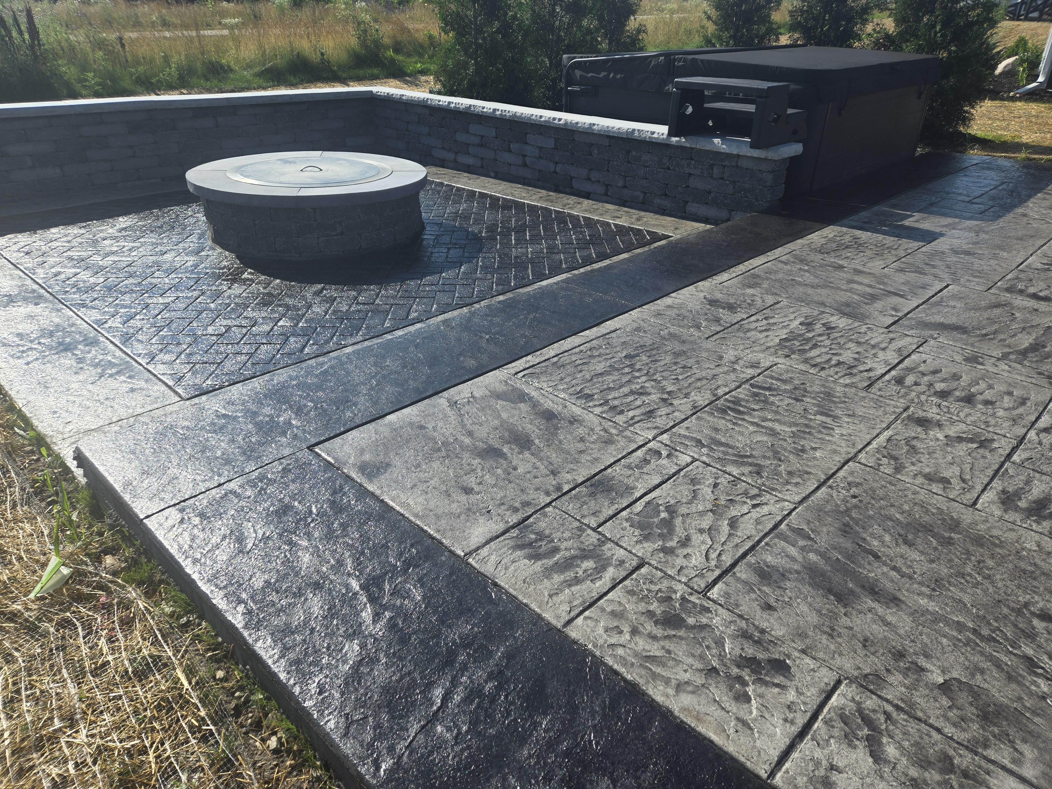 a stamped concrete patio and firepit