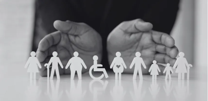 Hands surrounding a diverse group of paper figures, representing disability inclusion and workplace support.