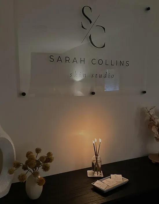 Portrait of the clinic founder in a softly lit treatment suite, professional and approachable.