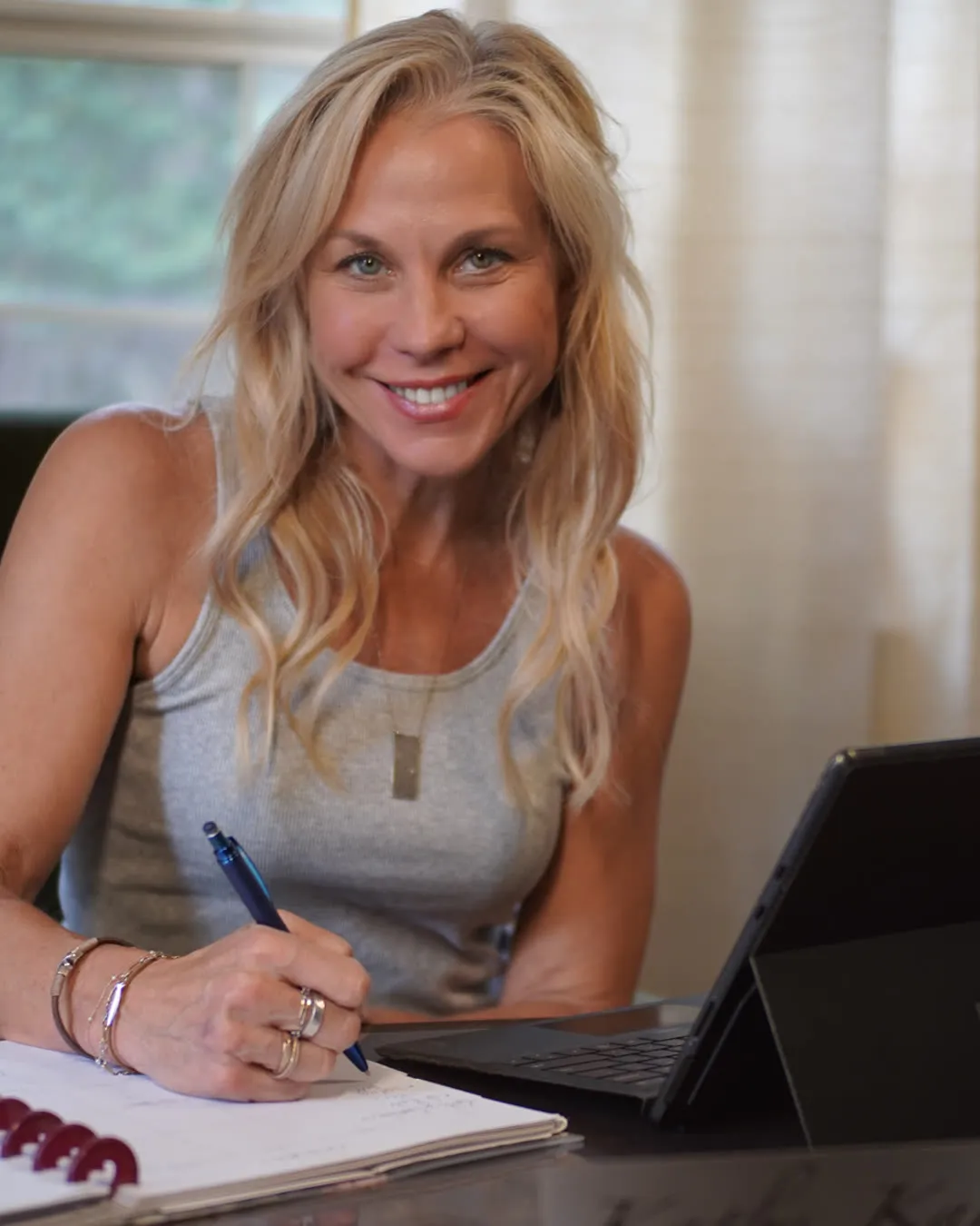 Kathy Kamburis at her desk, writing in a planner
