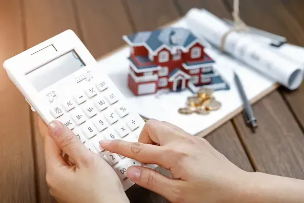 A woman operates a calculator to decide if she should refinance her home in 2026