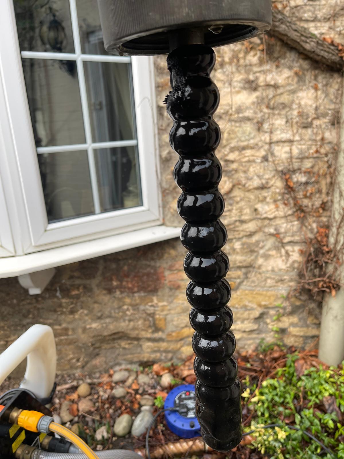 Magnetic filter rod covered in thick black magnetite sludge during a central heating power flush in HU7, Hull