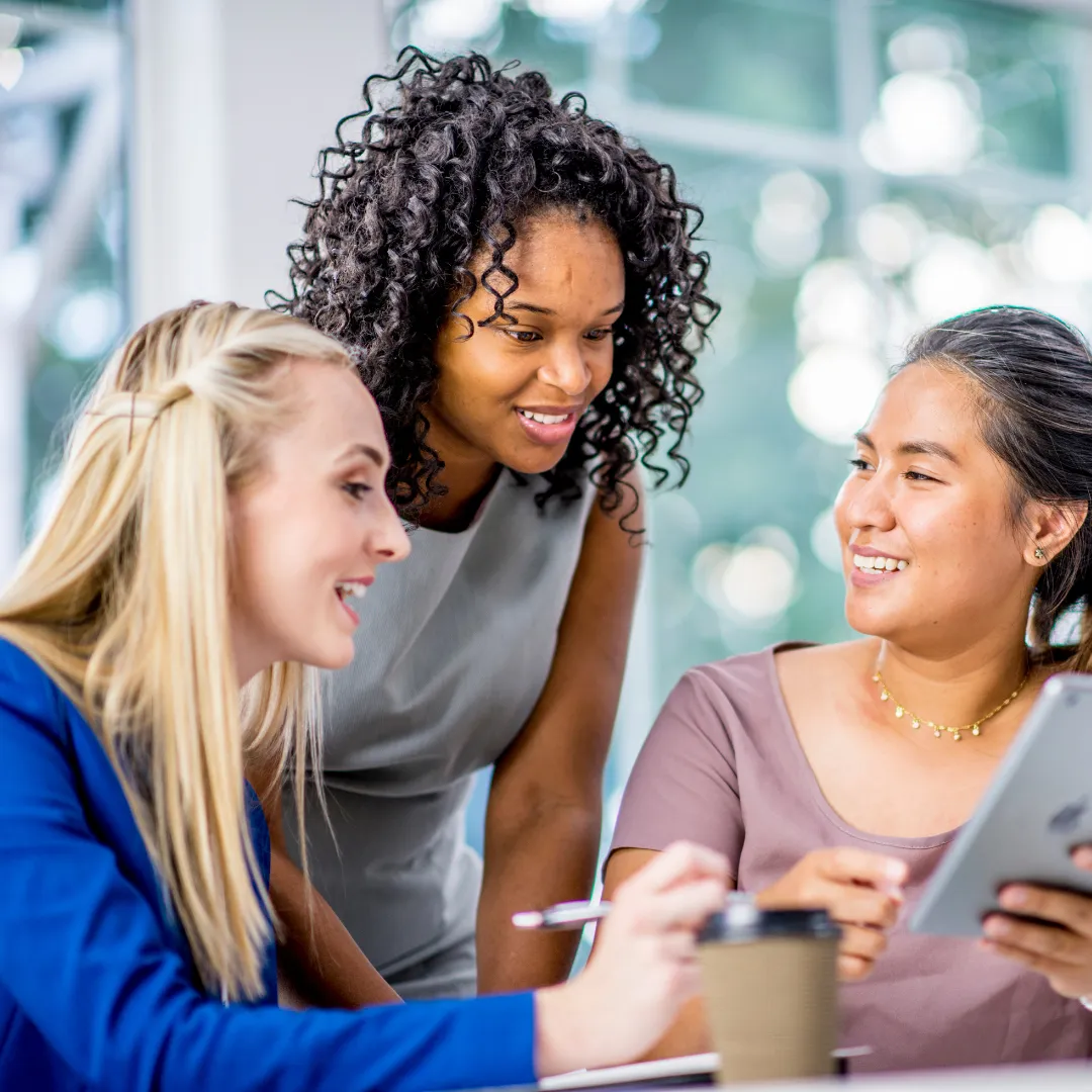 Three women looking at an iPad.