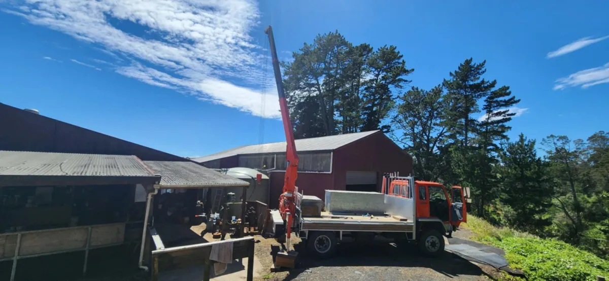Crane truck setup for pump cable installation at commercial job site in wet conditions
