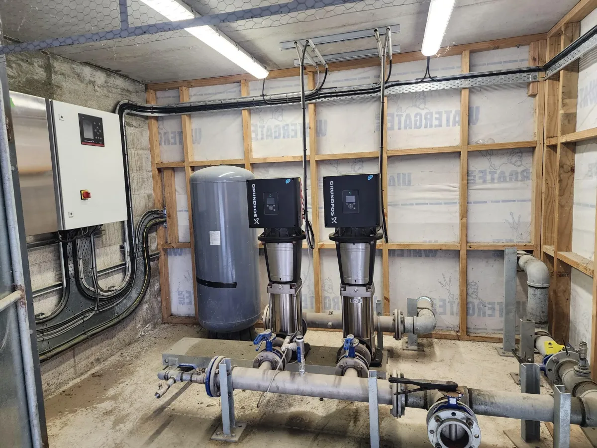 Installed Grundfos booster pumps with control systems in commercial pump room