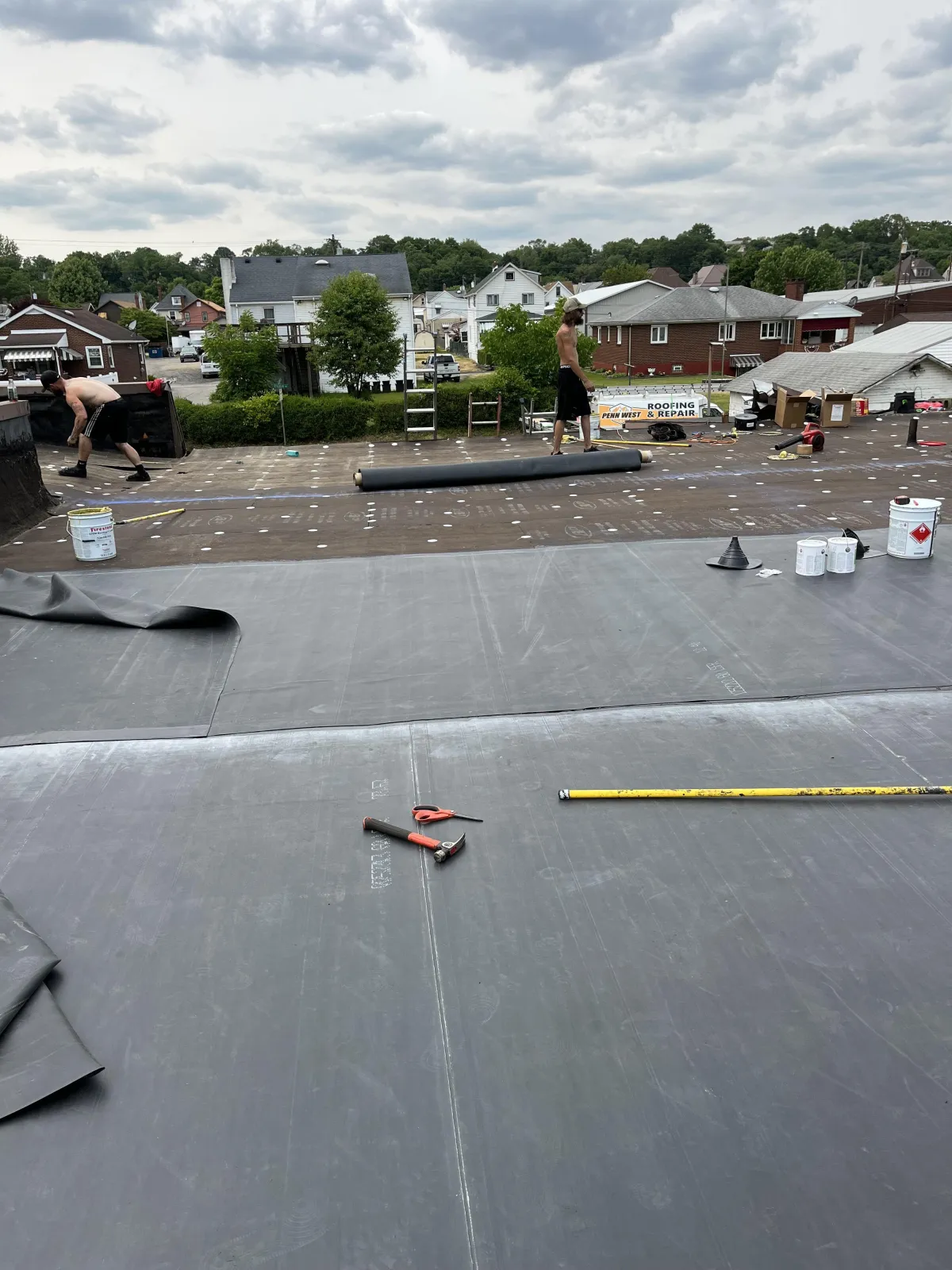 Commercial flat roof replacement in Brackenridge PA showing rubber membrane positioned and aligned during installation process