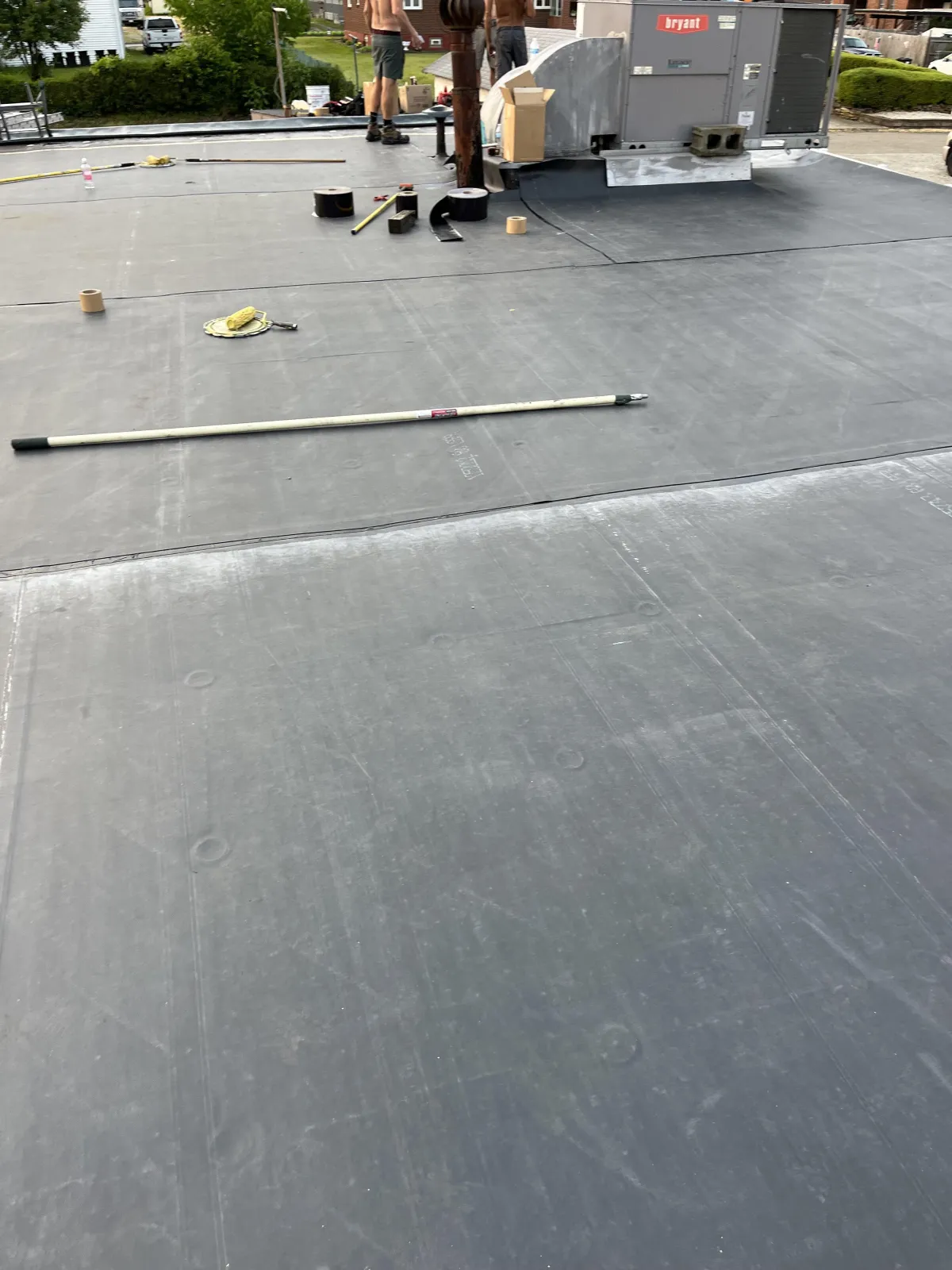 Commercial flat roof replacement in Brackenridge PA with rubber membrane installation around rooftop HVAC equipment
