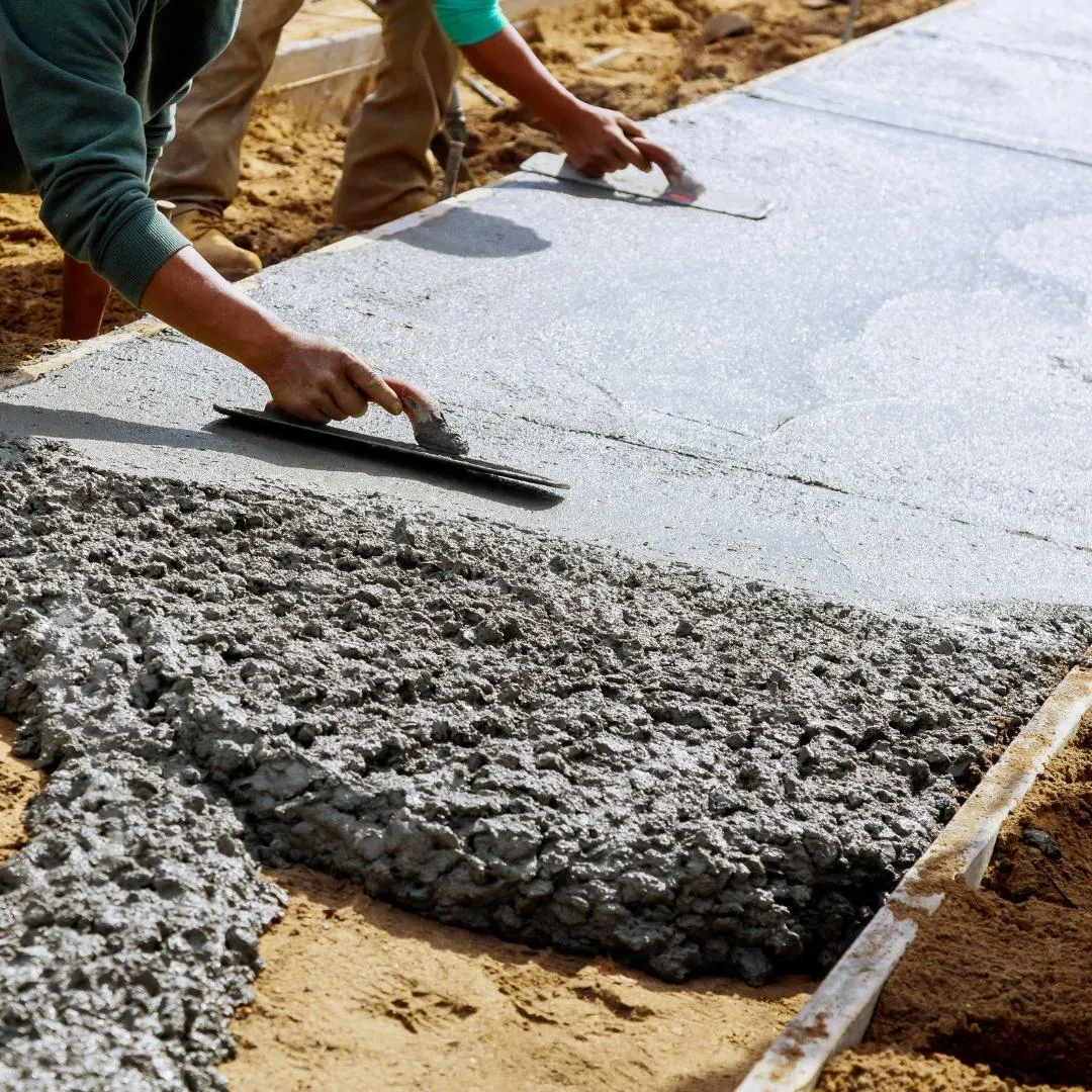 Concrete contractors smoothing cement concrete with tools