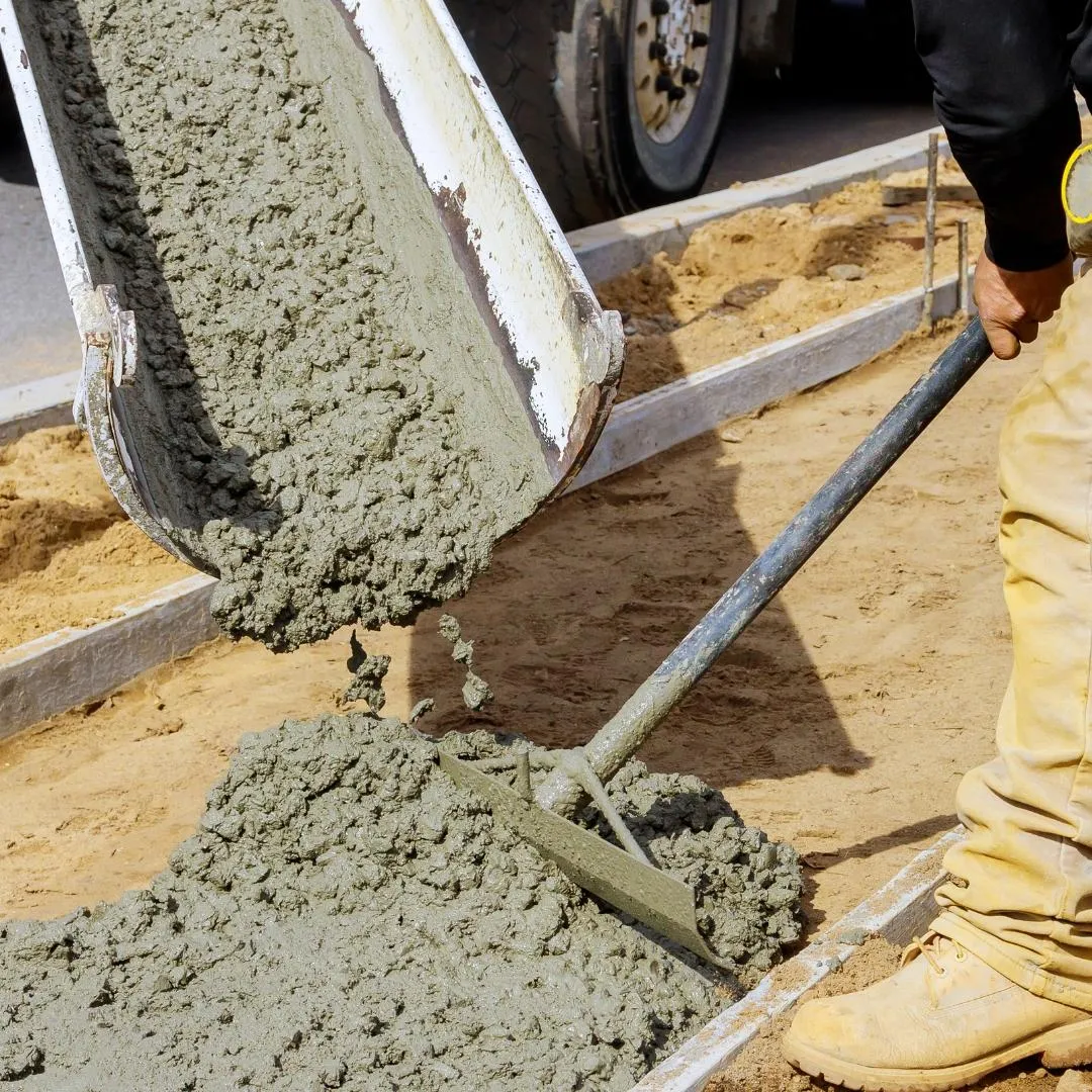 Concrete contractor pouring and smoothing concrete cement with tool