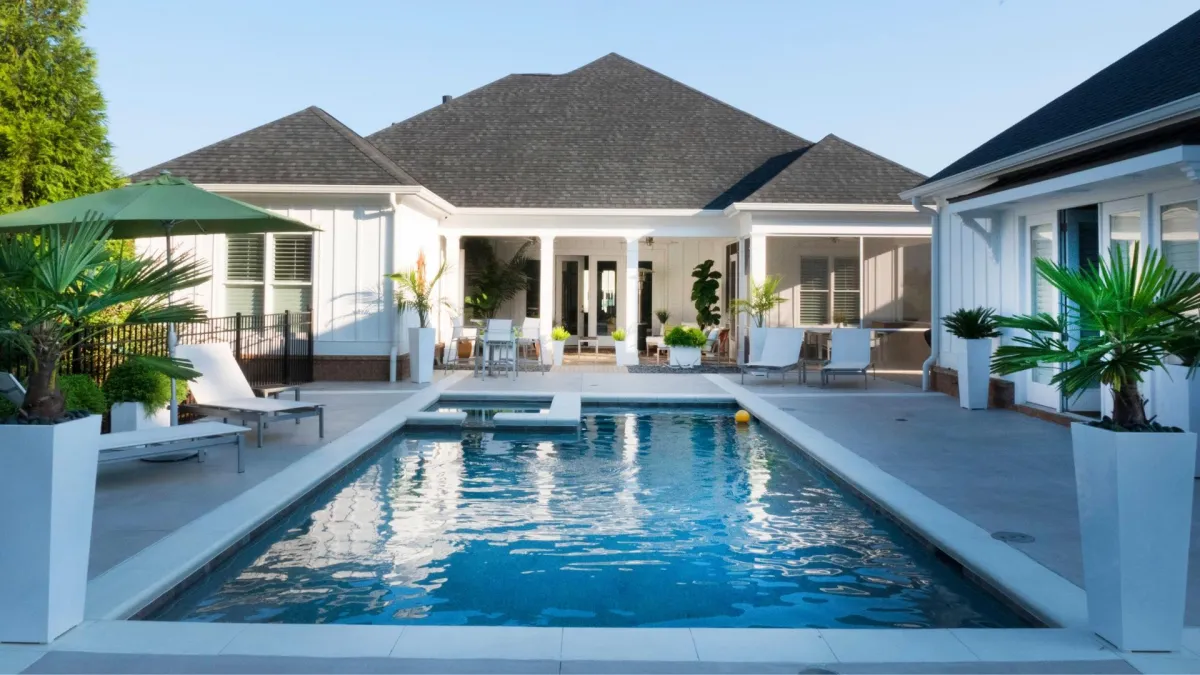 Concrete patio around pool in backyard