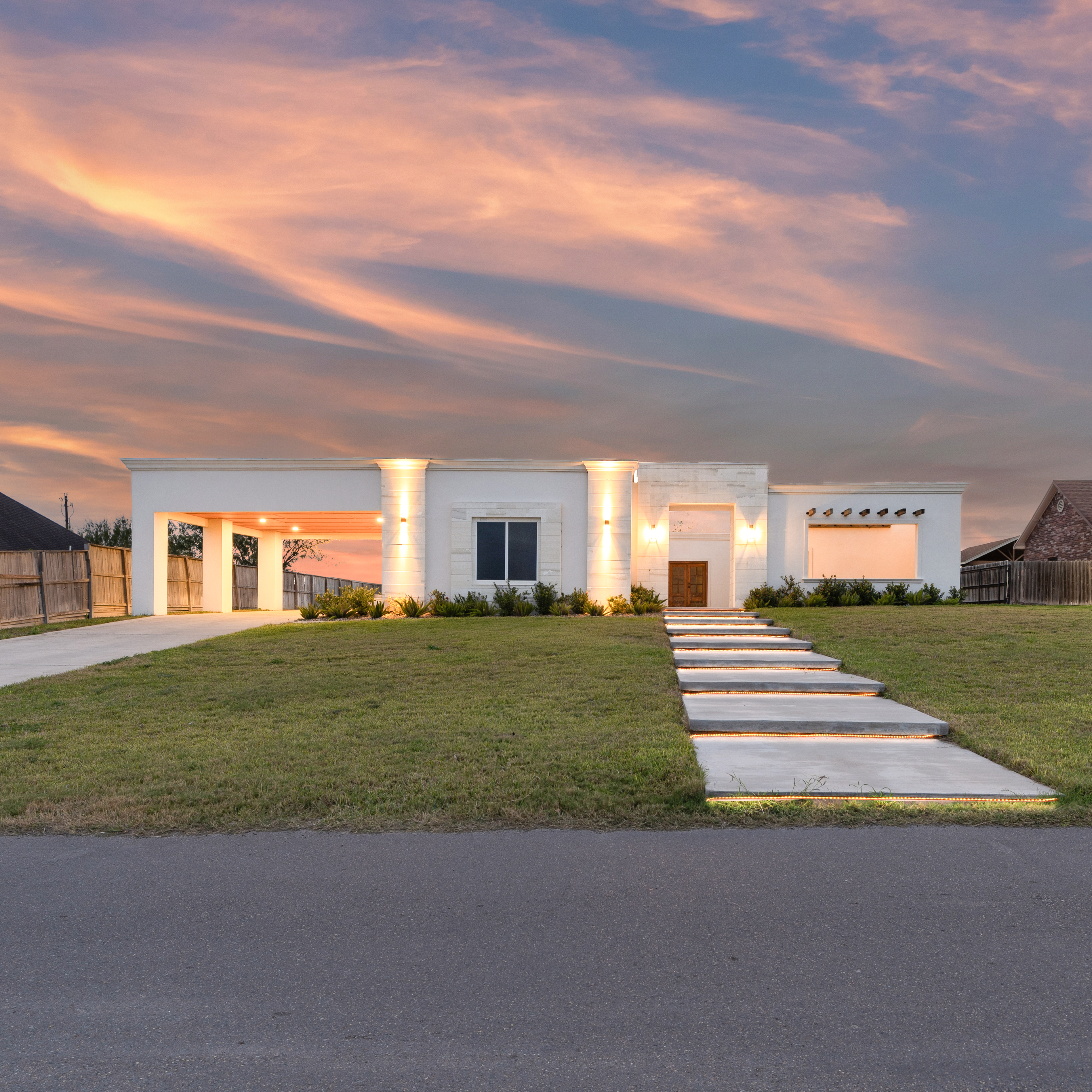 Brick modern farmhouse exterior with black metal roof, large windows, and covered front entry by South Texas Builders.