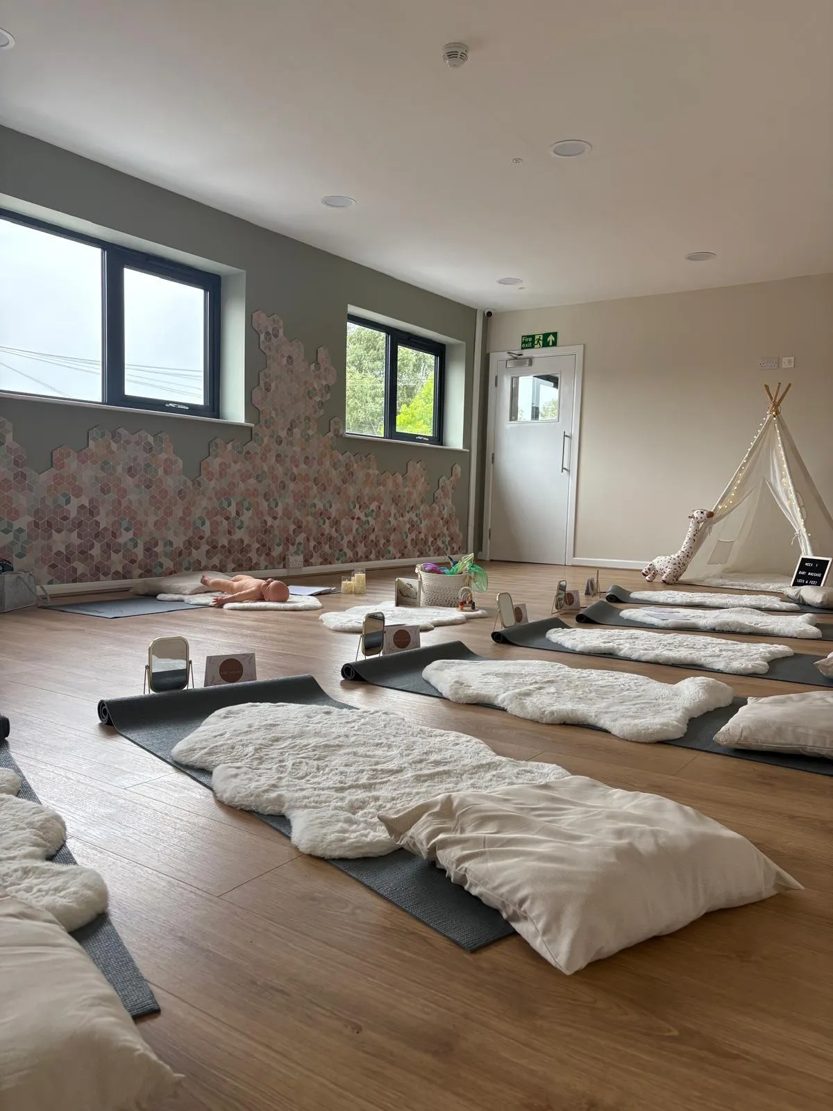 A hired room set up for baby massage, with week one written on a chalkboard