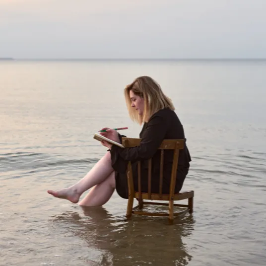 A woman sitting on a chair on water