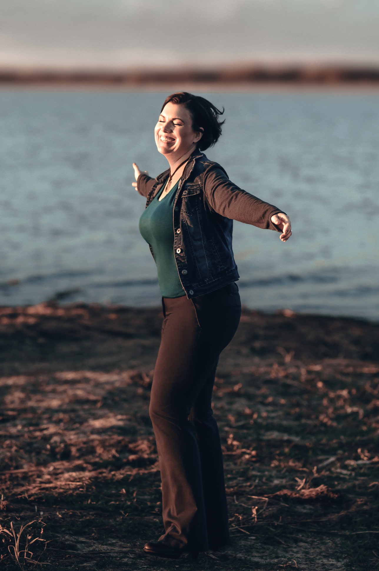 A warm, natural full body image of Peggy smiling and feeling the wind