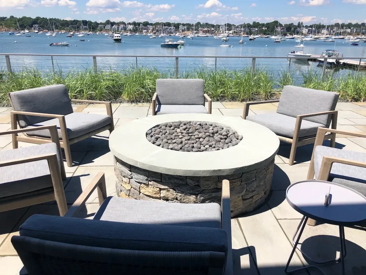Custom fire feature installation in Marblehead MA with oceanfront patio and harbor views.