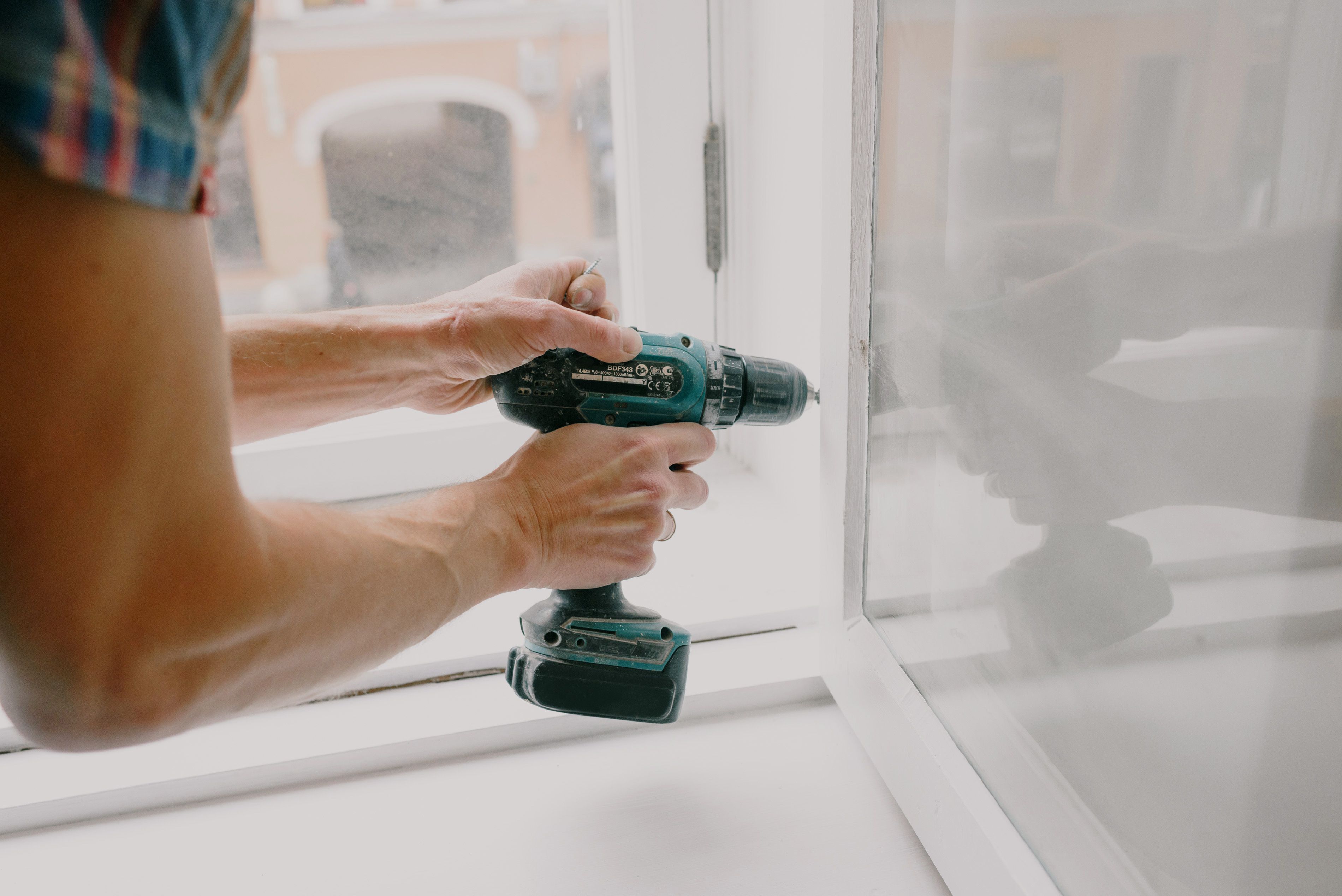 Handyman completing a window installation inside a home