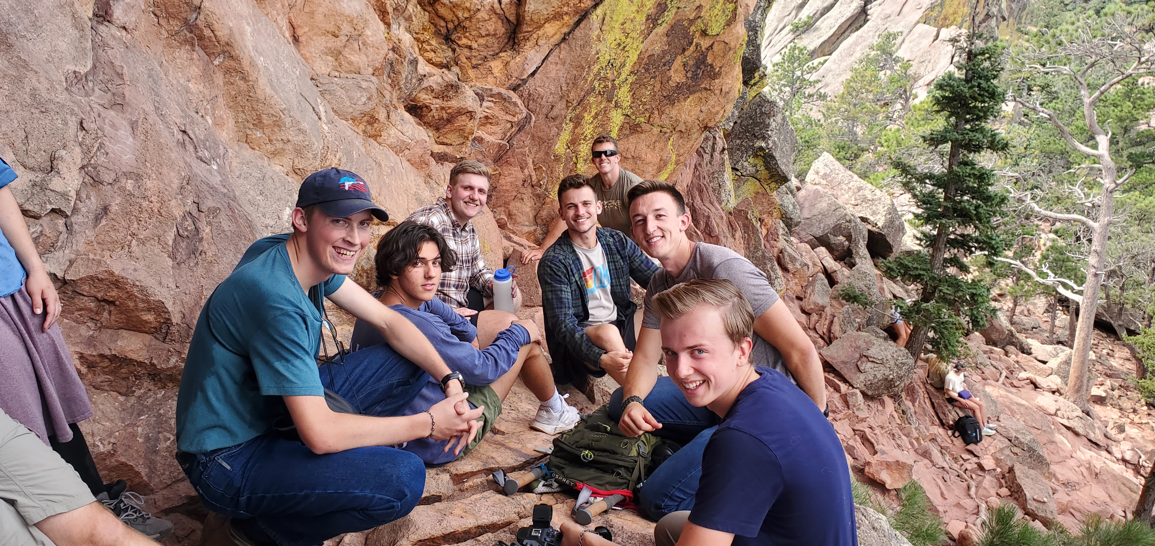 AI generated photo: small group of young adults in deep conversation at a candlelit dinner table, formal attire, warm amber tones, serious and alive, cinematic.