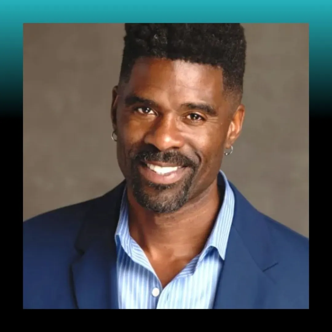 Headshot of a smiling man against a blue background