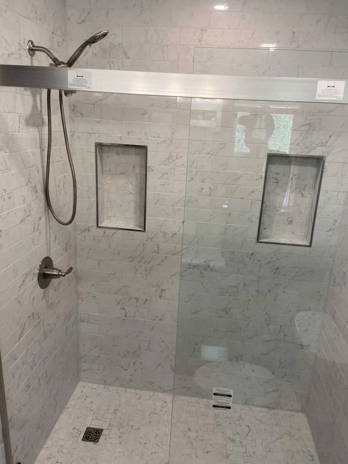Luxury bathroom renovation with a rustic wooden vanity, glass shower, and log cabin walls.