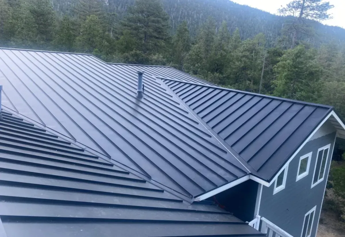 Dark grey standing seam metal roof on two story  residential home in Southern California installed by Dove Roofing