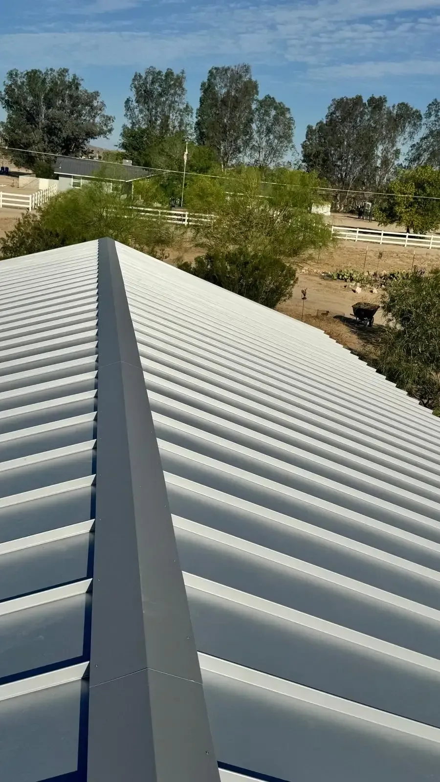 White standing-seam metal roof on rural property with desert trees — metal roofing Palm Springs CA