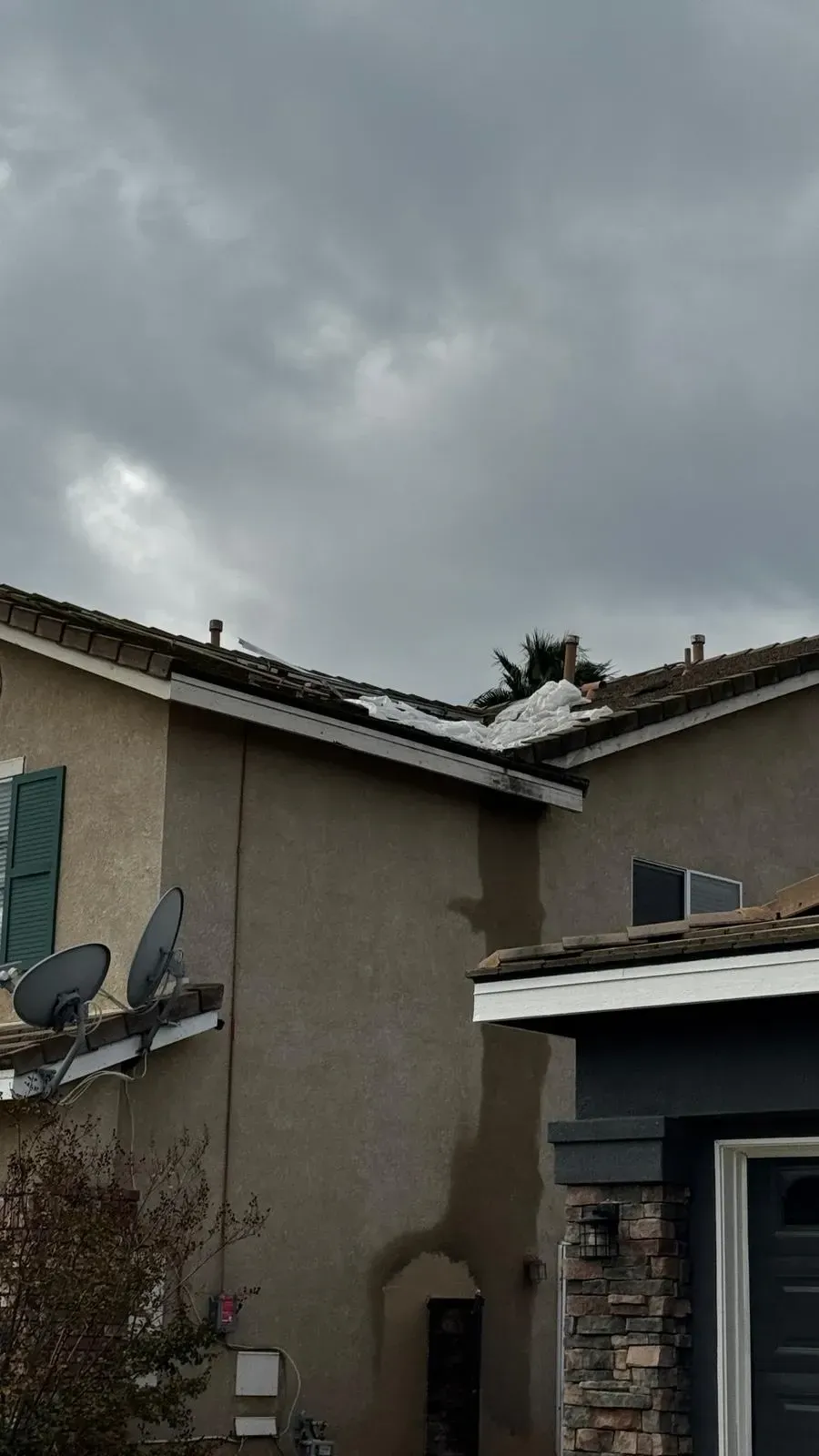 Storm damaged roof edge and parapet wall on Southern  California home assessed by Dove Roofing before repair
